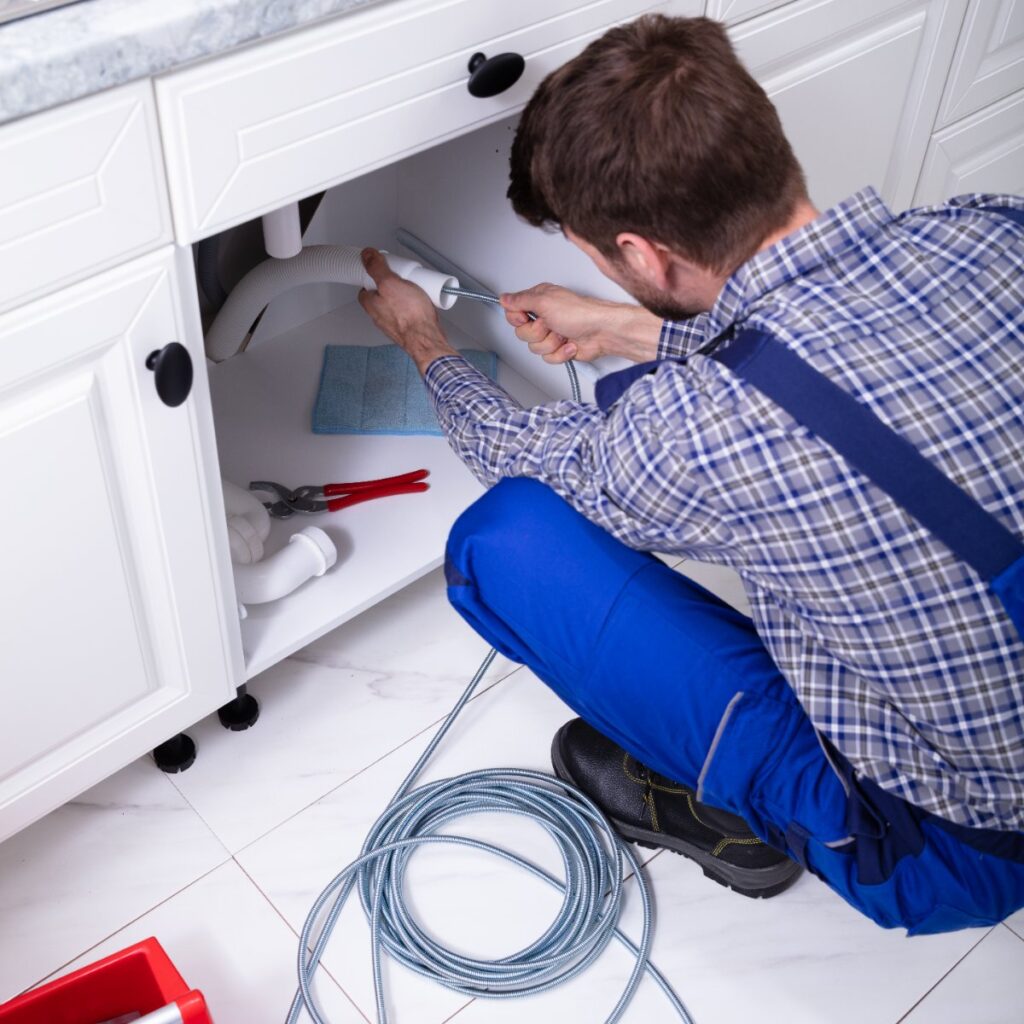 Plumber cleaning sink drain